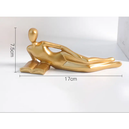 Golden reclining figure on a book.