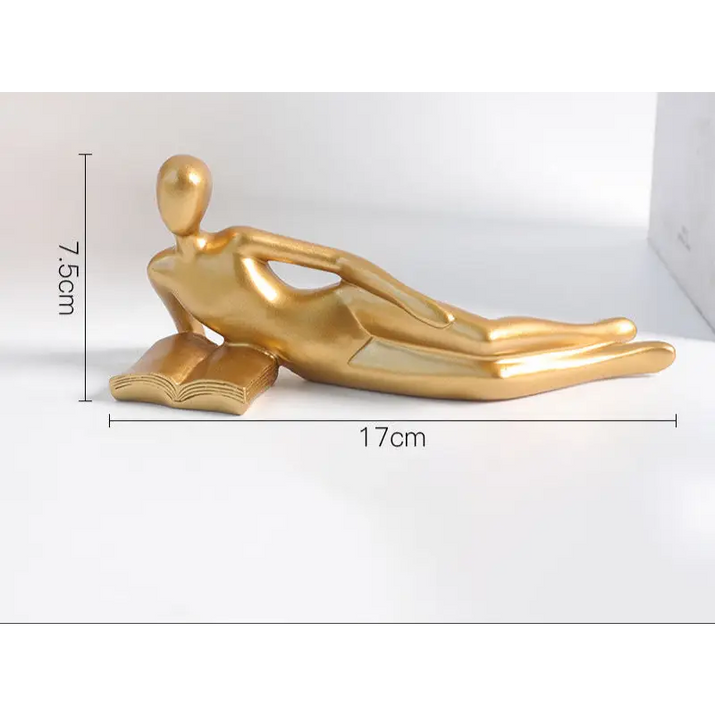 Golden reclining figure on a book.