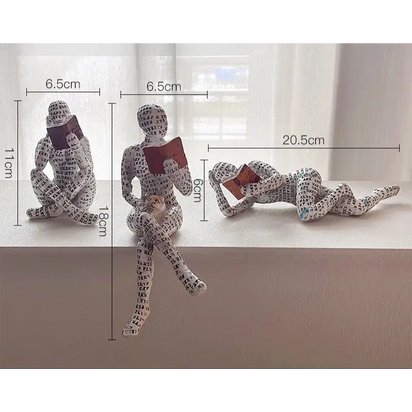 Three reading figure sculptures.