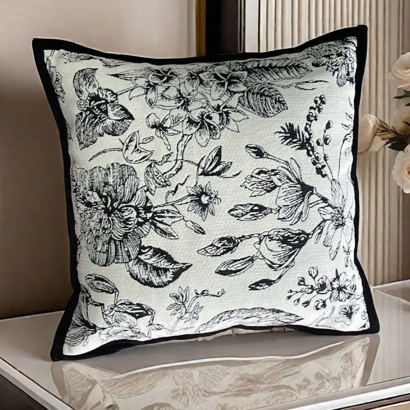 Floral patterned throw pillow with black trim.