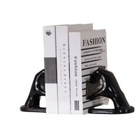 Black hand-shaped bookends with books.