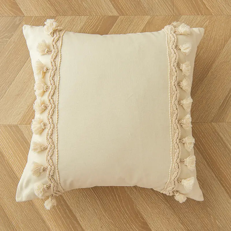 Square cream-colored Morocco Style Home throw pillow with tassel trim for a playful home decor