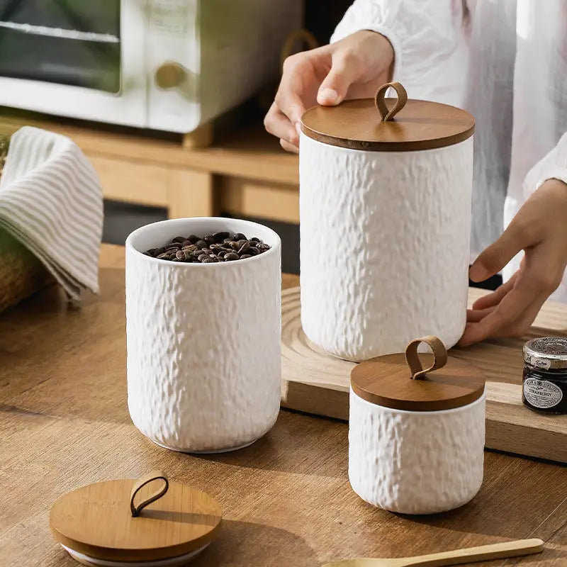 Textured white ceramic canister set with wooden lids for stylish kitchen storage