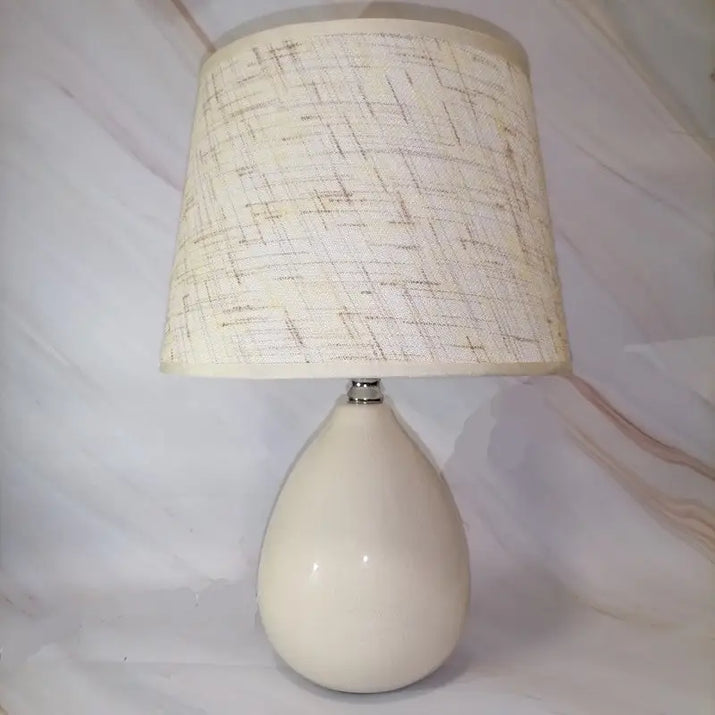 Cream-colored lamp with textured shade.