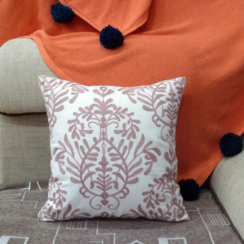 Embroidered white throw pillow.