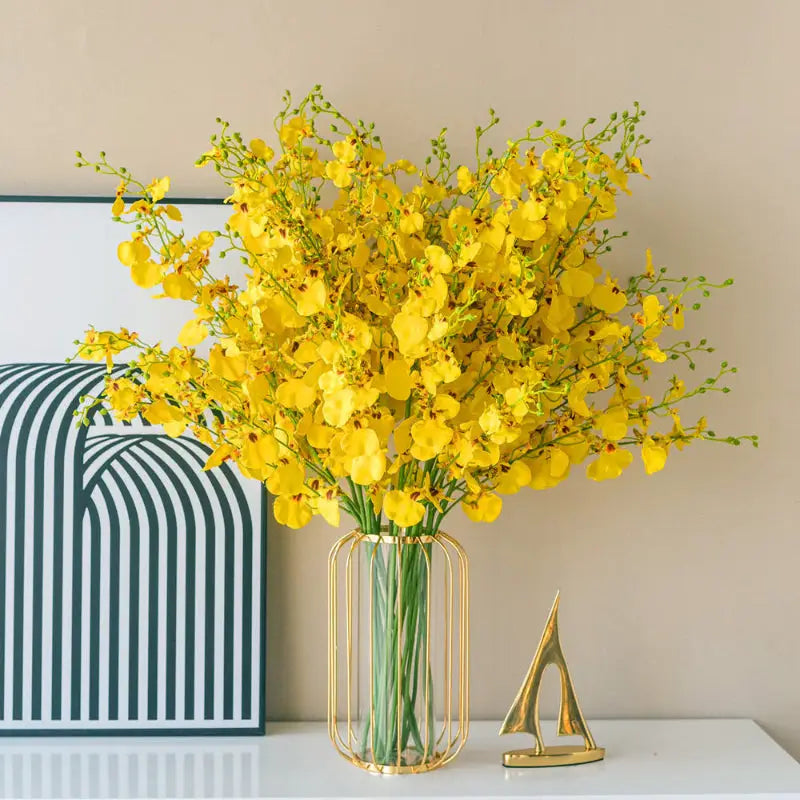 Yellow orchids in a gold vase.