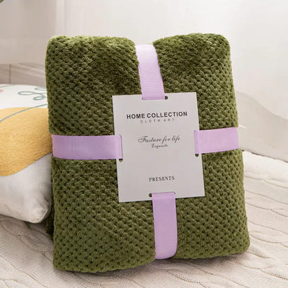 Olive green textured blanket with lavender ribbon.