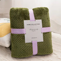 Olive green textured blanket with lavender ribbon.