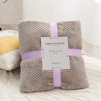 Folded gray plush blanket with ribbon and tag.