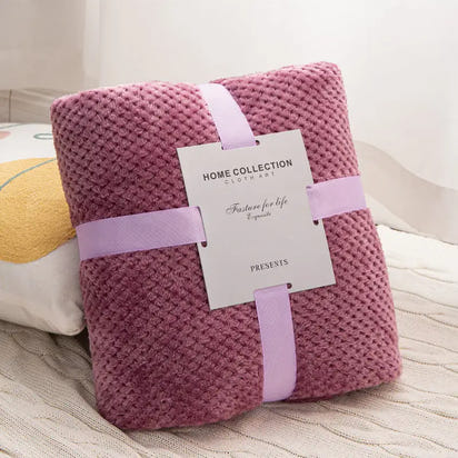 Mauve textured blanket with ribbon and tag.
