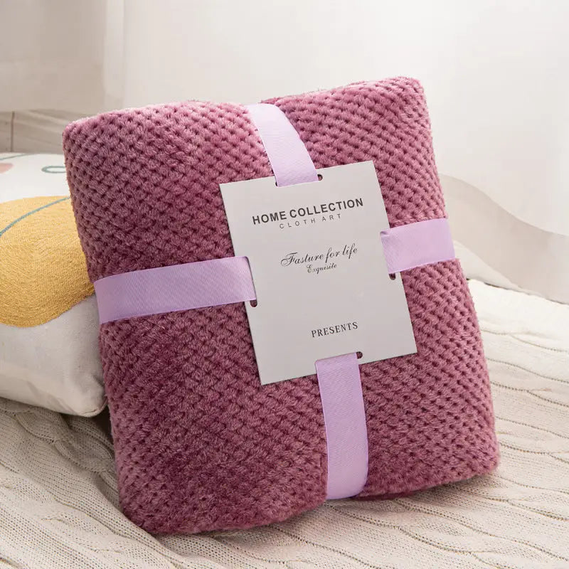 Mauve textured blanket with ribbon and tag.