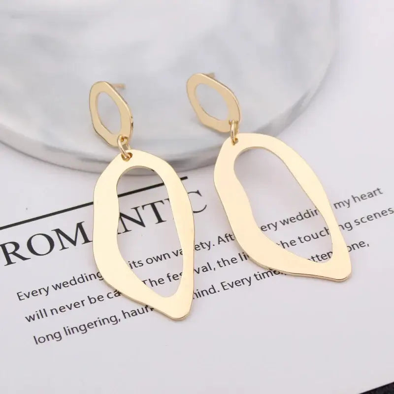 Gold abstract dangle earrings featuring retro charm and statement metal long drop design