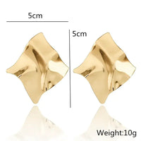 Pair of gold square crinkled earrings showcasing retro charm in statement metal long drop earrings