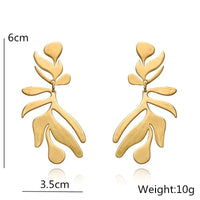Gold leaf-shaped long drop earrings with retro charm in statement metal long design