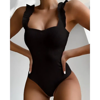 Black ribbed one-piece swimsuit with ruffled straps.