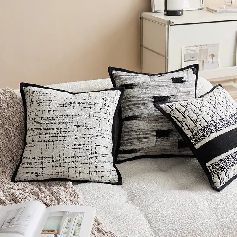 Decorative black and white throw pillows on a simple modern soft sofa cushion