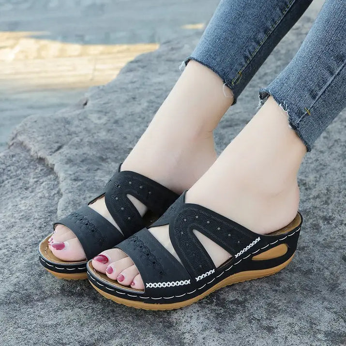 Black wedge sandals with embroidered details, perfect for quirky slip-on style