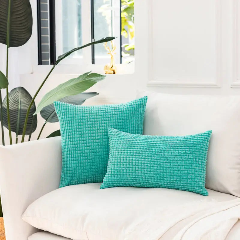 Two turquoise corduroy pillows on Soft Plaid Corn Kernel Square Cushion for cozy decor