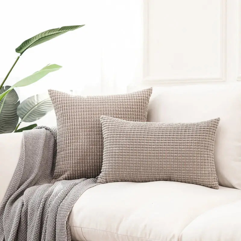 Textured gray throw pillows on Soft Plaid Corn Kernel Square Cushion for cozy decor