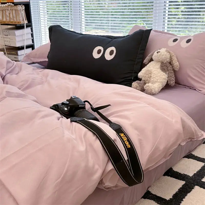 Camera on a pink bedspread.
