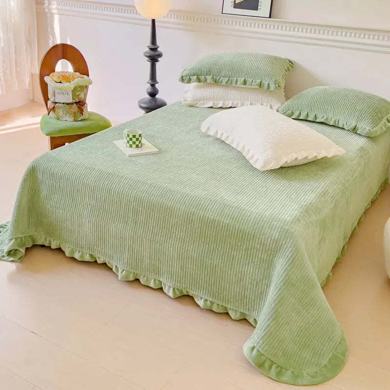 Green corduroy bedspread with ruffled edges.