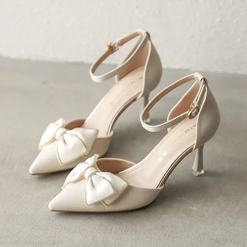 Beige ankle-strap heels with bow detail.