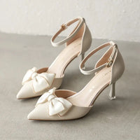 Beige ankle-strap heels with bow detail.
