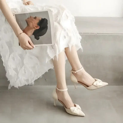 Cream-colored high heels with bow detail.