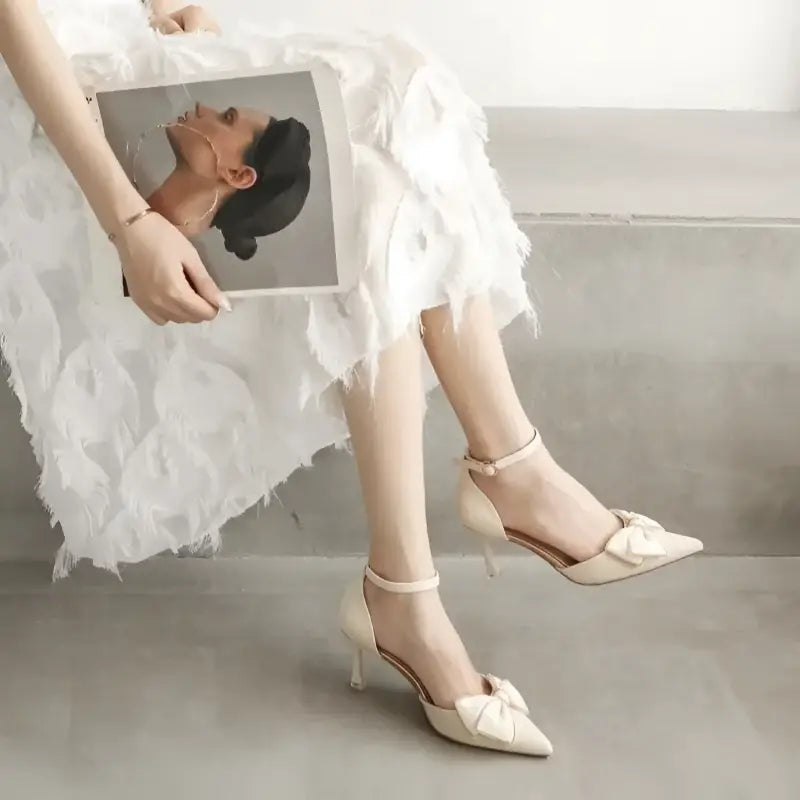 Cream-colored high heels with bow detail.