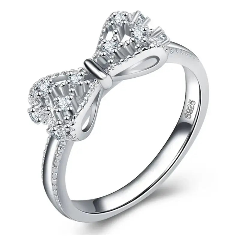 Silver bow ring with embedded crystals.