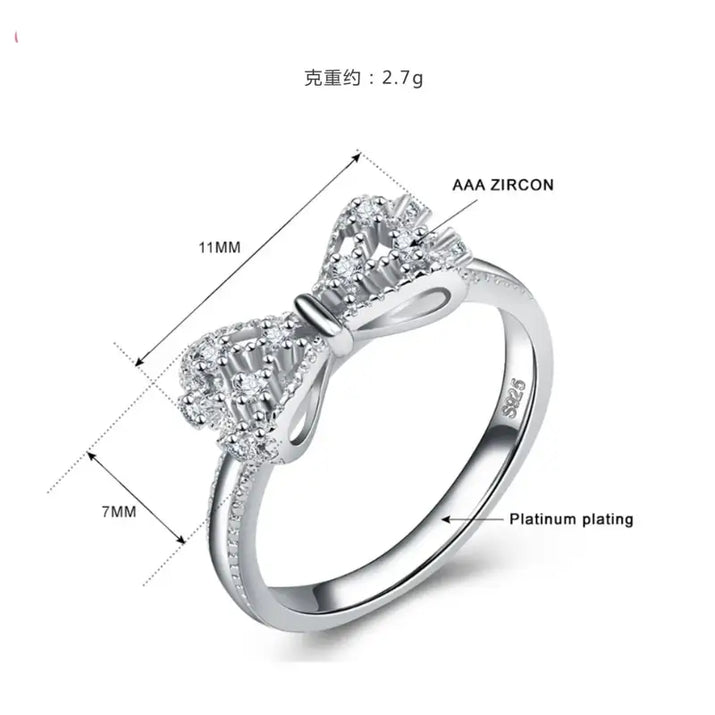 Silver bow ring with zircon stones.