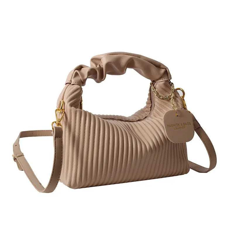 Beige textured vertical stripe handbag with pleated design, ruffled handle, and shoulder strap