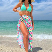 Woman in a floral skirt and turquoise bikini.