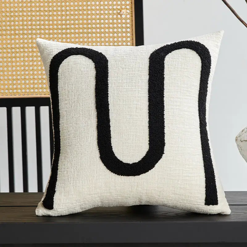 Textured white pillow with black U-shaped twisted strip sofa throw cushion design