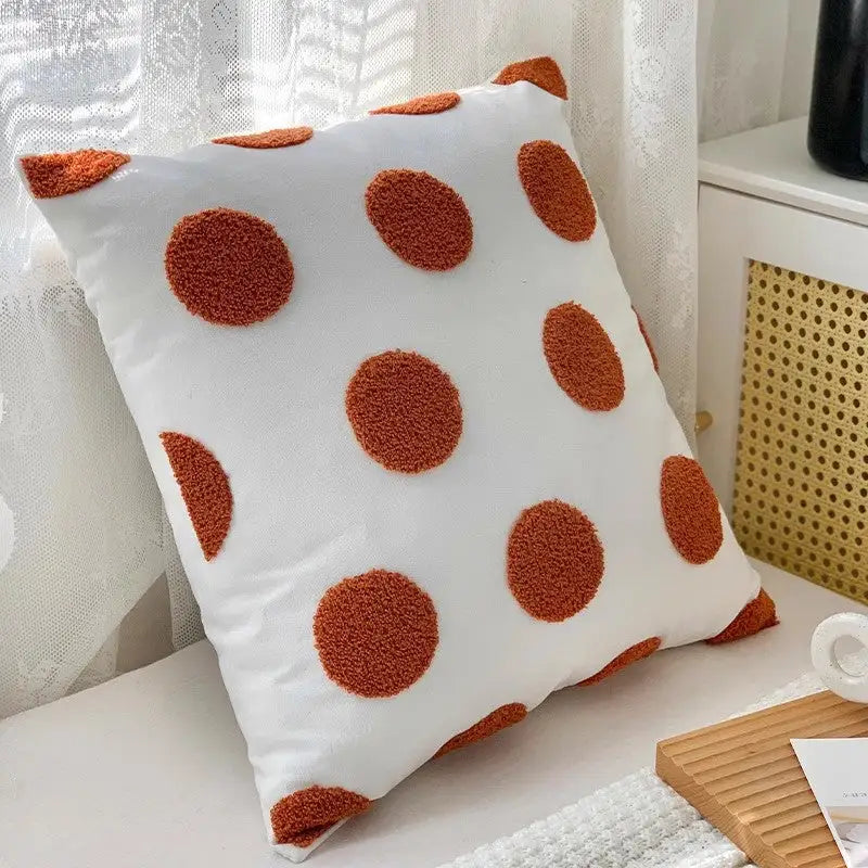 White pillow with orange polka dots on twisted strip sofa throw cushion for stylish comfort