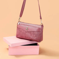 Floral-patterned, mauve crossbody bag.