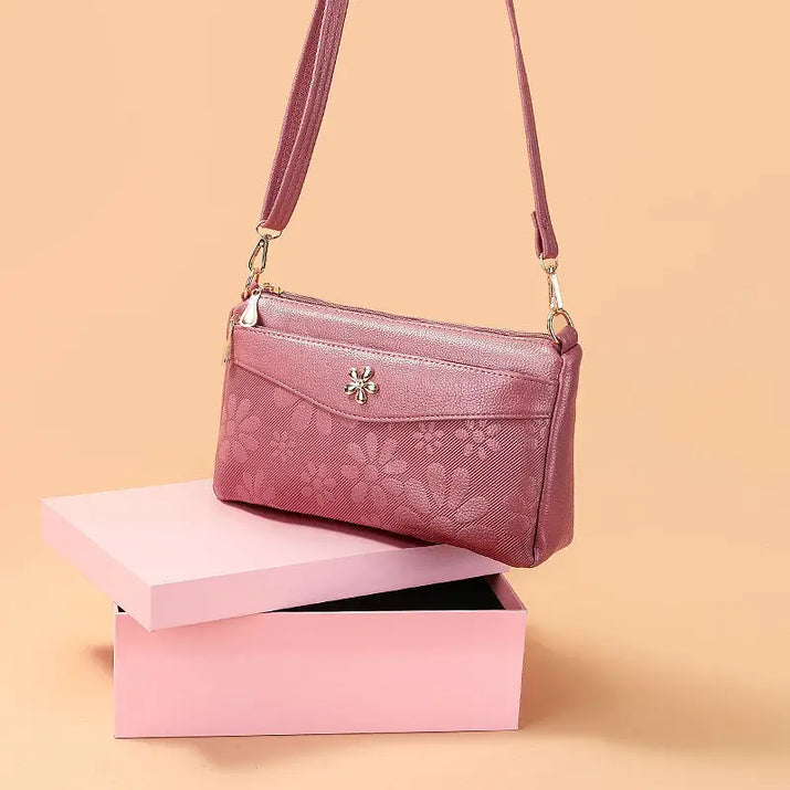 Floral-patterned, mauve crossbody bag.