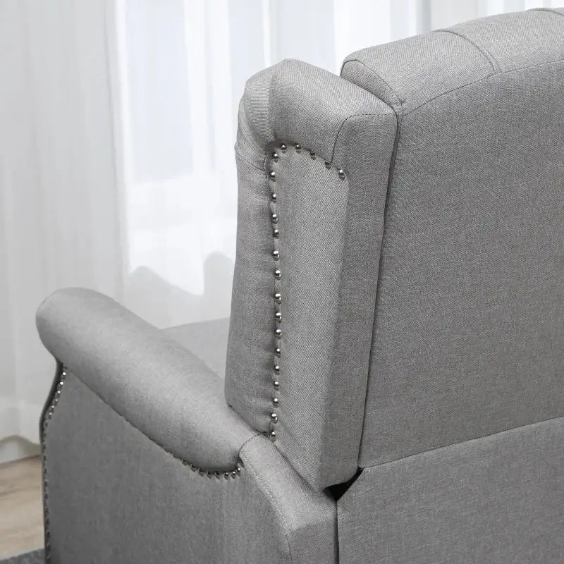 Gray upholstered wingback reclining chair with nailhead trim, perfect for relaxing