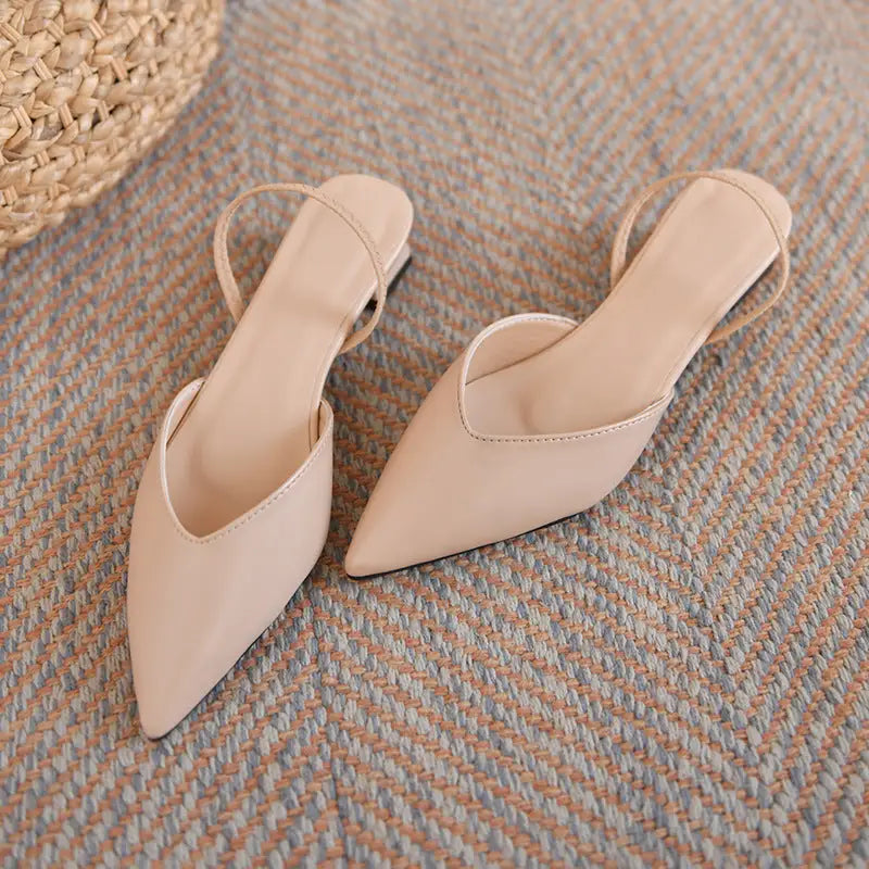 Beige pointed-toe slingback flats.