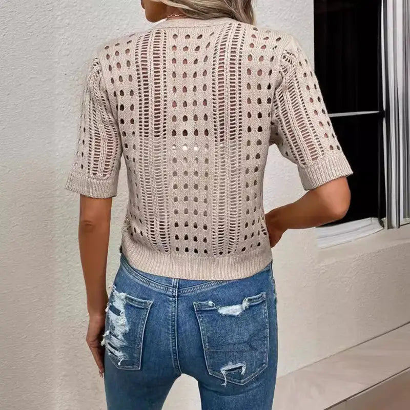 Beige knit top with holes.